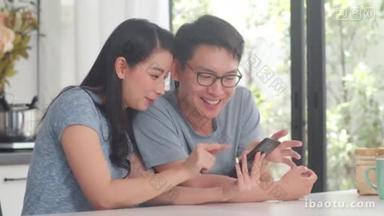 一对年轻的亚洲夫妇喜欢在家里用手机上网购物。 